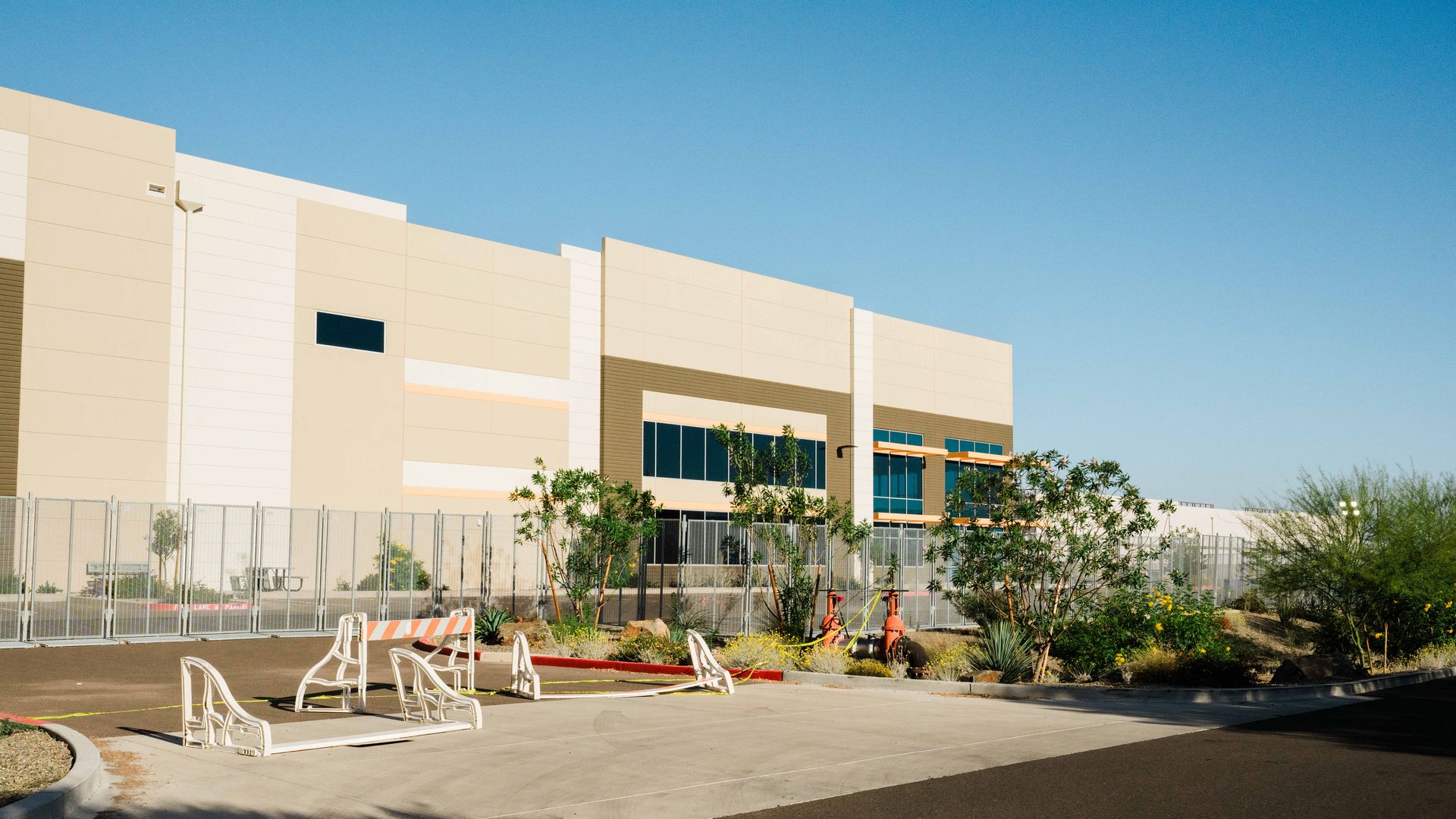 A large warehouse-style building in Surprise, Arizona being converted into an ICE immigration detention facility in an industrial desert landscape
