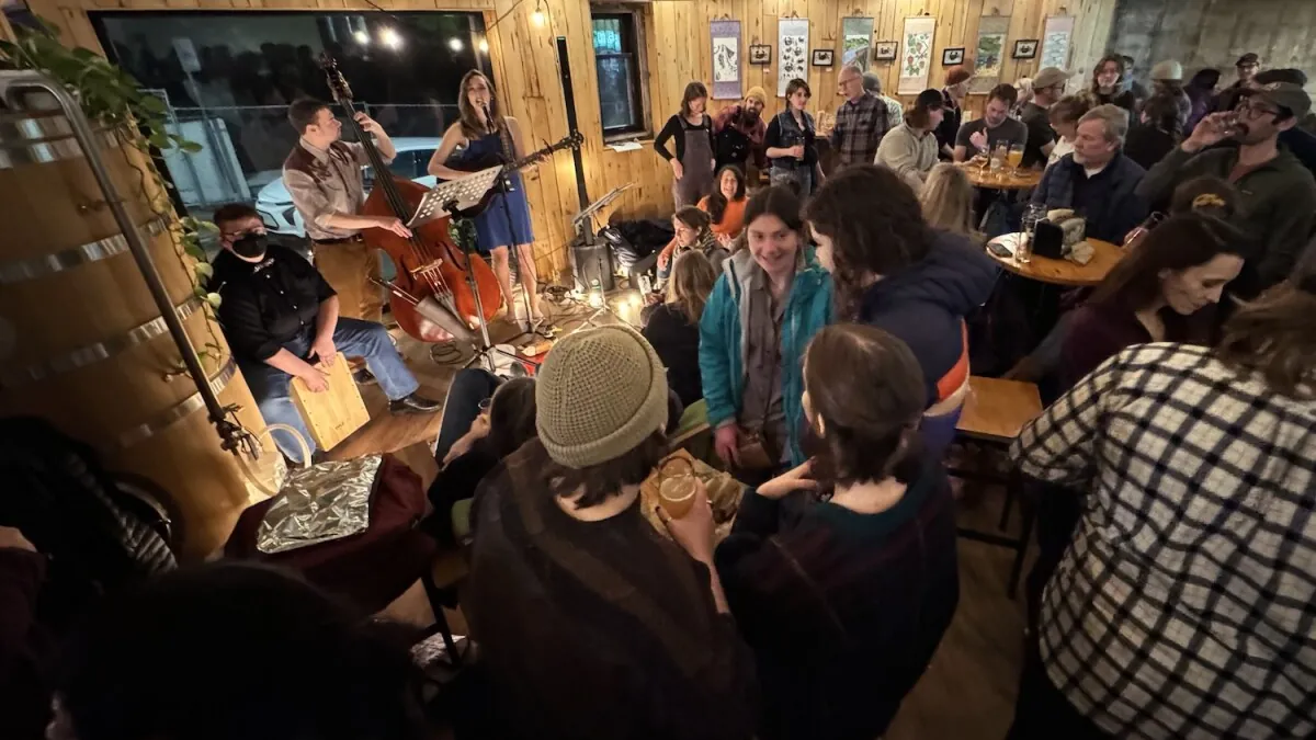 Live music performed inside a brewery taproom with patrons seated nearby