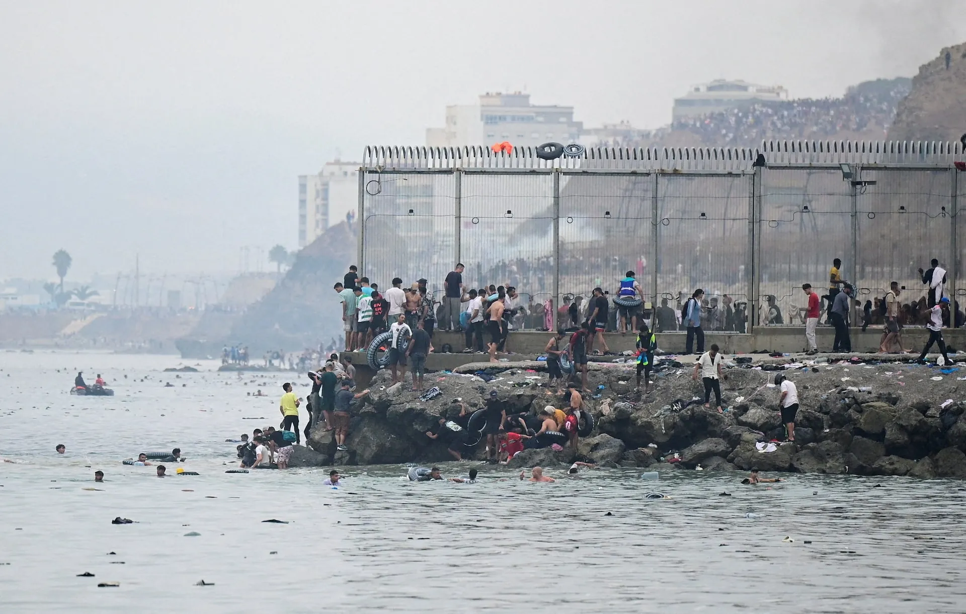 Crowds of migrants and Spanish security forces along the Ceuta border perimeter during the July 31, 2026 surge