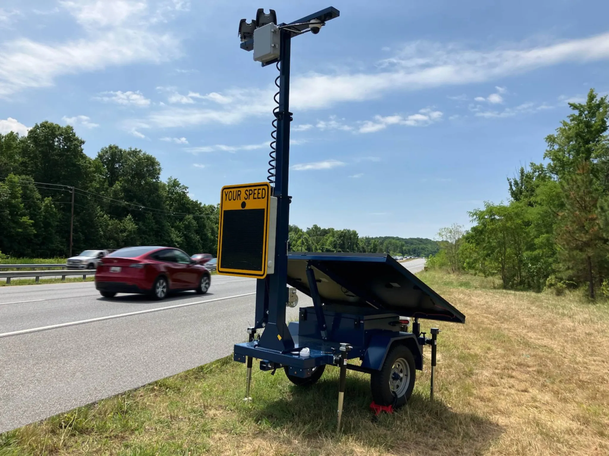 Blue Jenoptik automated enforcement trailer deployed on a roadside