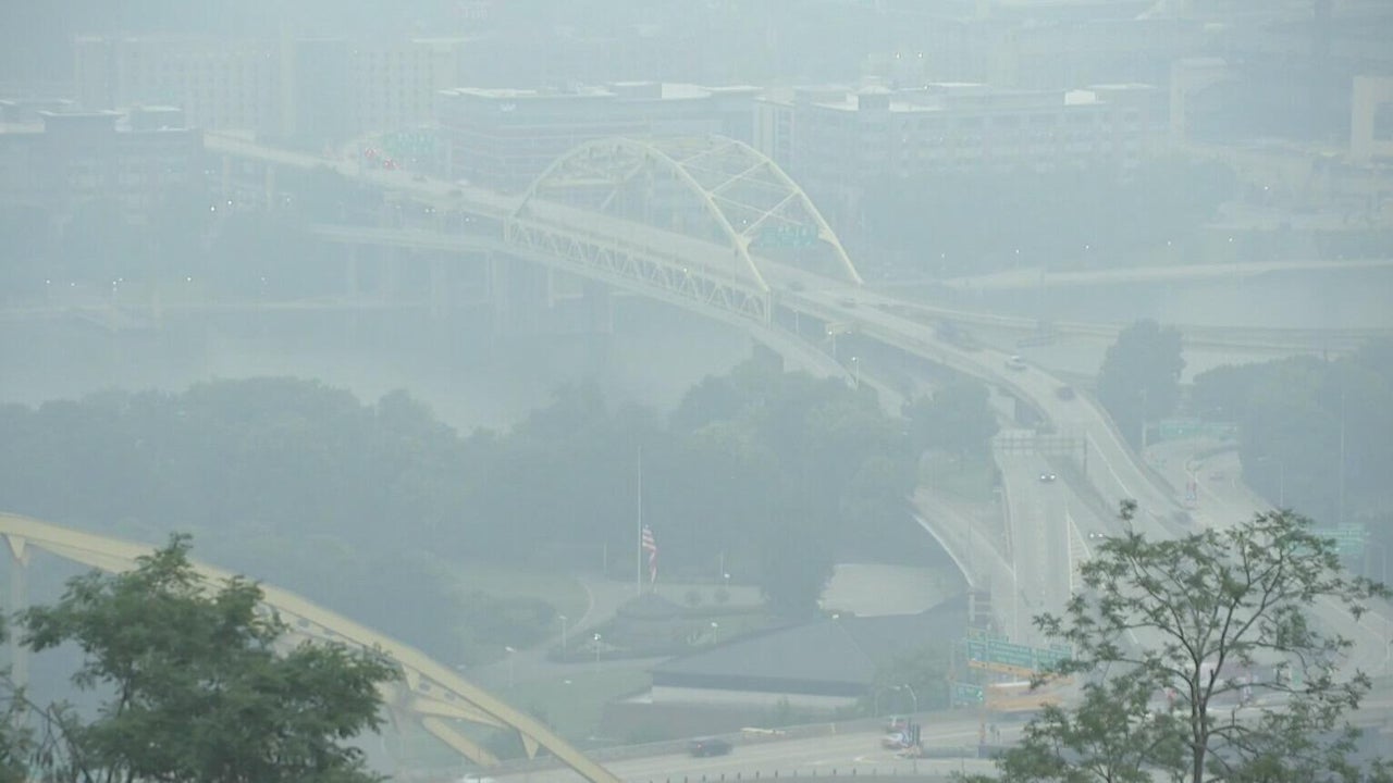 Hazy Pittsburgh skyline shrouded in orange-brown wildfire smoke during the July 2026 Code Purple air quality event