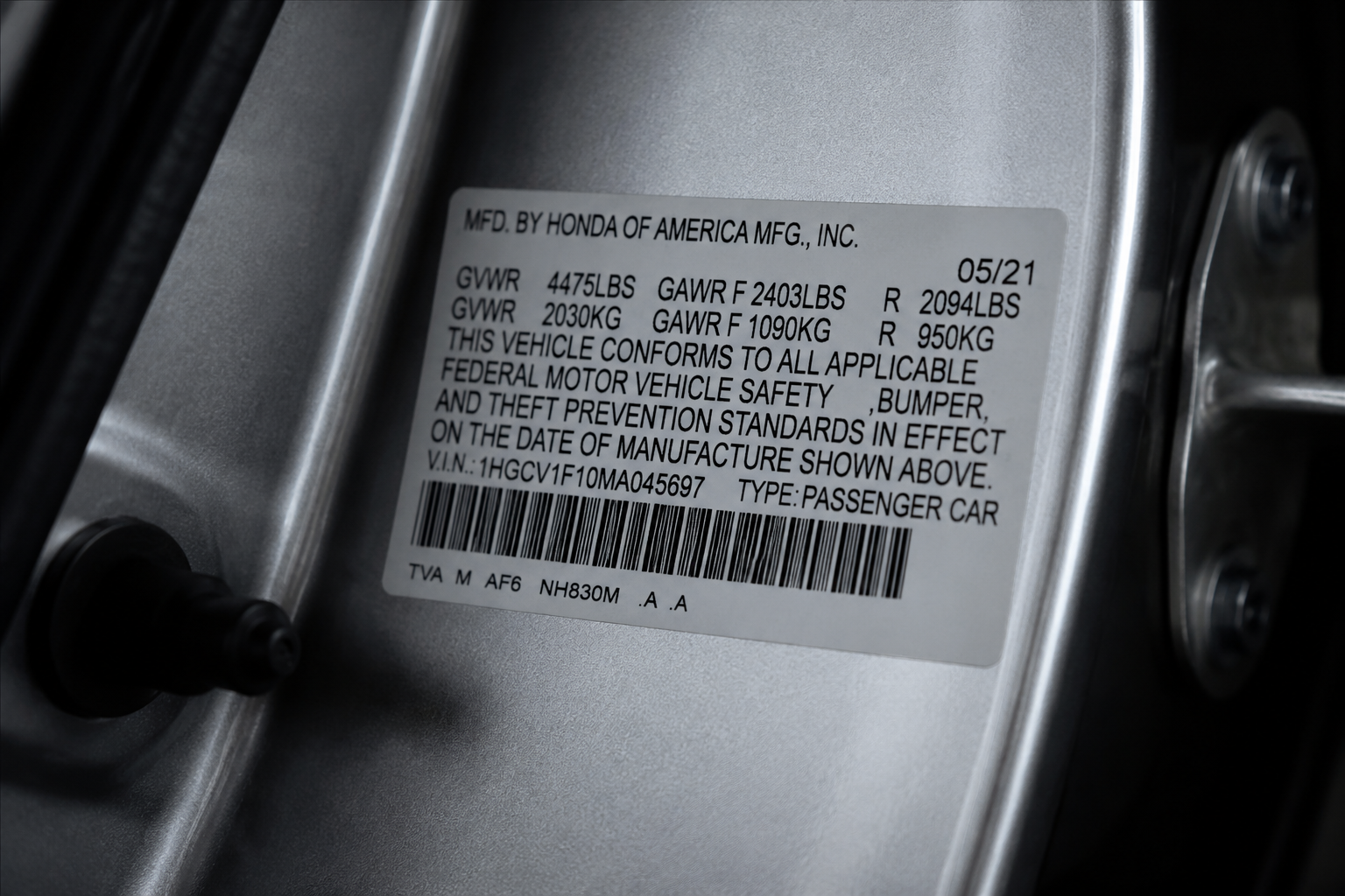 Vehicle certification label on a car door jamb showing GAWR and GVWR information