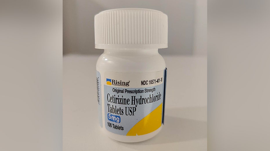 Bottle of cetirizine hydrochloride tablets with label visible
