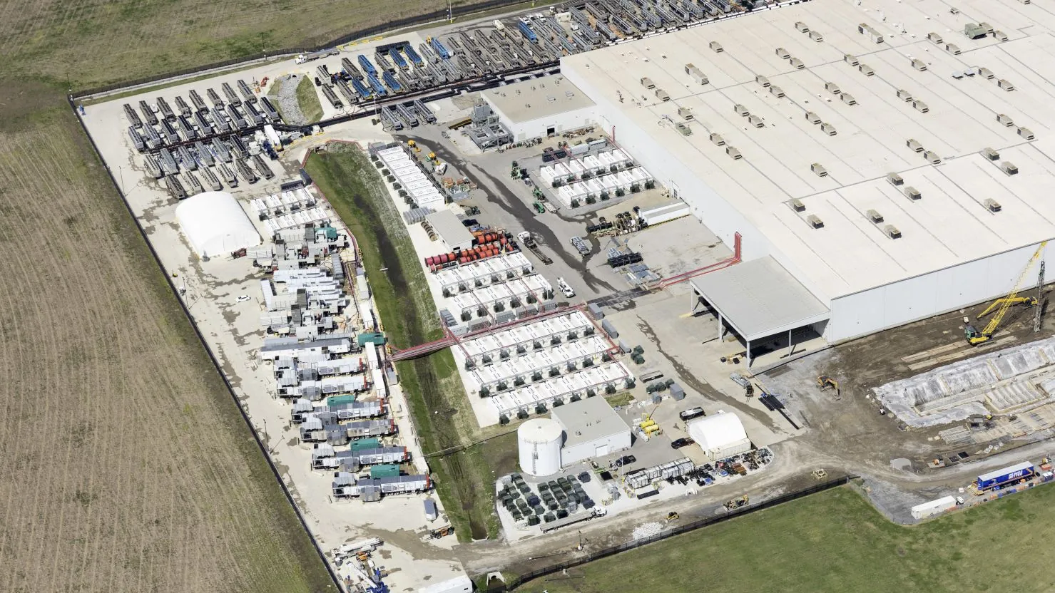 Aerial view of the xAI Colossus data center campus with rows of gas turbine units and industrial support equipment