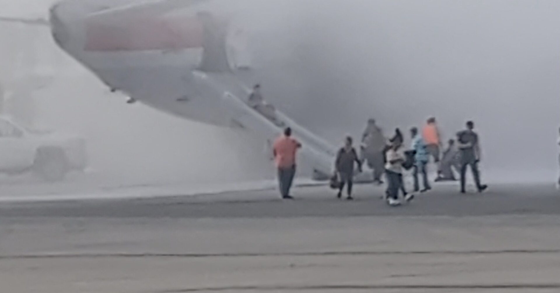 American Airlines Boeing 737-800 at Denver International Airport with emergency vehicles nearby and visible fire damage around the right engine